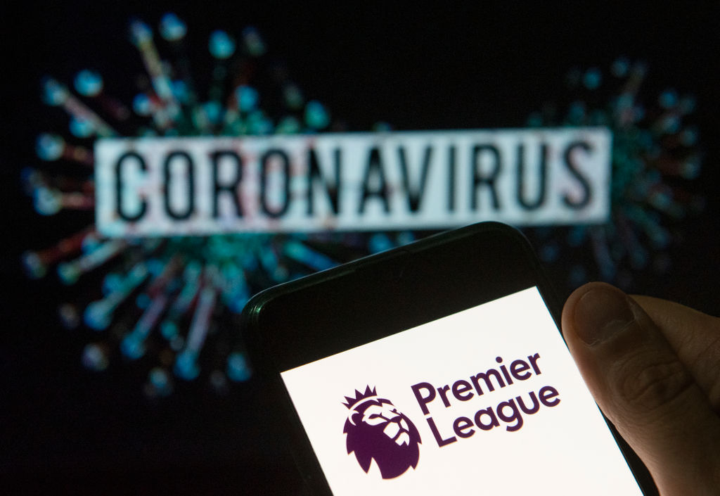 CHINA - 2020/03/24: In this photo illustration the top level of the English football league Premier League logo seen displayed on a smartphone with a computer model of the COVID-19 coronavirus on the background. (Photo Illustration by Budrul Chukrut/SOPA Images/LightRocket via Getty Images)