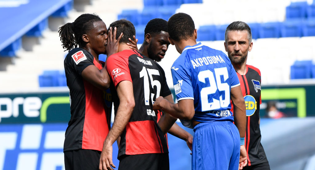 SINSHEIM, GERMANY - MAY 16: Dedryck Boyata of TSG 1899 Hoffenheim talks to teammate Serbian Marko Grujic during the Bundesliga match between TSG 1899 Hoffenheim and Hertha BSC at PreZero-Arena on May 16, 2020 in Sinsheim, Germany. The Bundesliga and Second Bundesliga is the first professional league to resume the season after the nationwide lockdown due to the ongoing Coronavirus (COVID-19) pandemic. All matches until the end of the season will be played behind closed doors. (Photo by Thomas Kienzle/Pool via Getty Images)