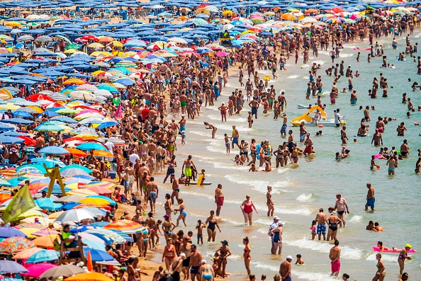 BENIDORM, SPAIN - JULY 22:  People sunbathe at Levante Beach on July 22, 2015 in Benidorm, Spain. Spain has set a new record for visitors, with 29.2 million visitors in June, 4.2% more than the same period in 2014. Spain is also expected to be the main destination of tourists seeking a value-for-money all-inclusive holiday after the Tunisia attack.  (Photo by David Ramos/Getty Images)