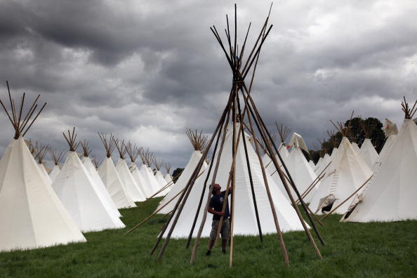 GLASTONBURY, ENGLAND - JUNE 18:  Jodie Webb, a crew member from Boutique Camping erects a tipi in the tipi field on the Glastonbury Festival site at Worthy Farm, Pilton on June 18 2009 near Glastonbury, Engand. Next week, the tipis, which are fully booked and cost 800GBP to hire, will be occupied by festival goers joining more that 170,000 other music fans, enjoying more than three days of live music at what is generally considered Europe's biggest music festival.  (Photo by Matt Cardy/Getty Images)
