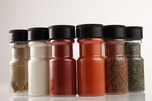 Close-Up Of Spices In Bottles Against White Background