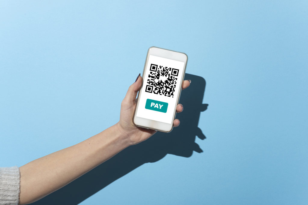 Woman with the qr code for payment on her smart phone