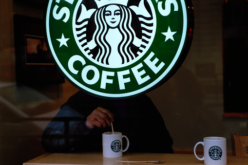 Customer Behind Starbucks Sign in London