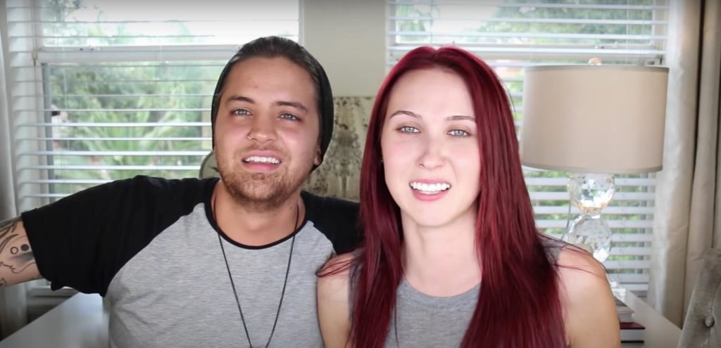 Jon and Jaclyn Hill look directly into the camera, both wearing grey T-shirts, while recording a YouTube broadcast