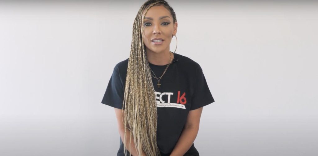 Medium shot of radio host Lady Jade wearing a Project 16 T-shirt in front of a white background, looking straight into the camera