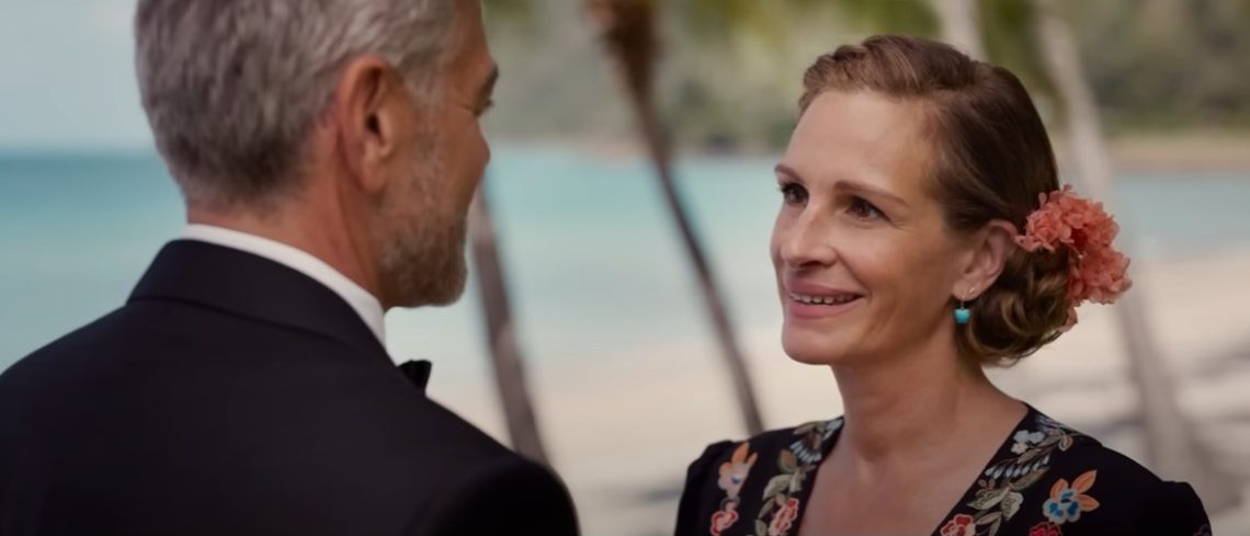 Julia Roberts stares up at George Clooney wearing a tuxedo on the beach in Bali in Ticket To Paradise