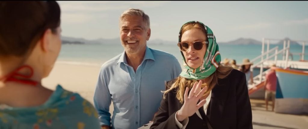 Julia Roberts stands next to George Clooney on the beach as they meet their on-screen daughter in Ticket To Paradise
