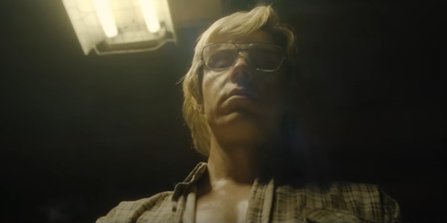 Evan Peters, playing Jeffrey Dahmer, looks down at the camera