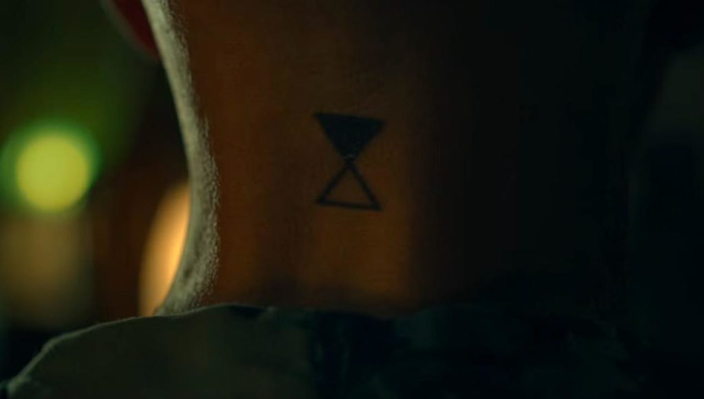 Tatuaje de reloj de arena visto en el cuello de Heather Langenkamp en The Midnight Club