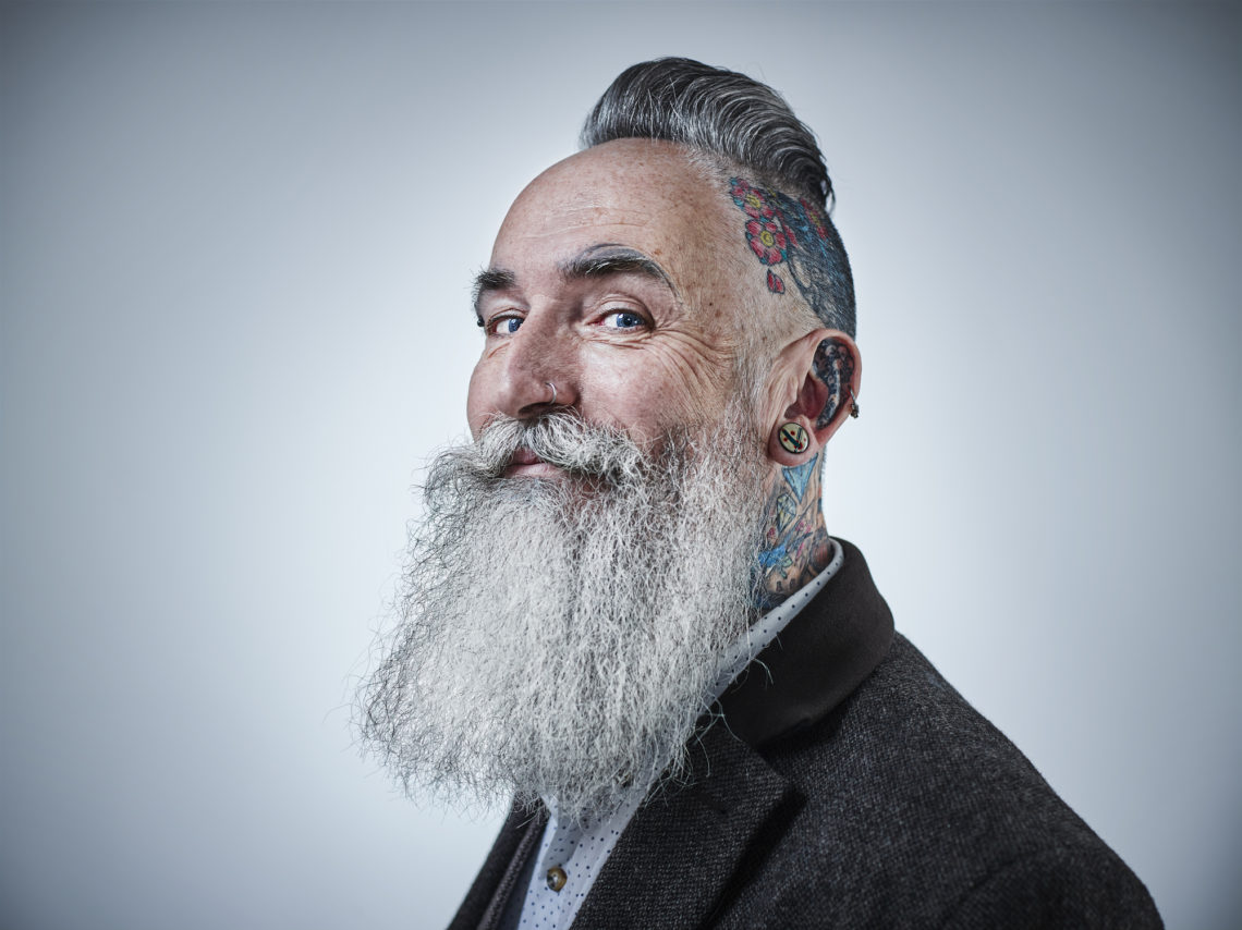 Portrait of mature male with tattooed head and long, bushy beard
