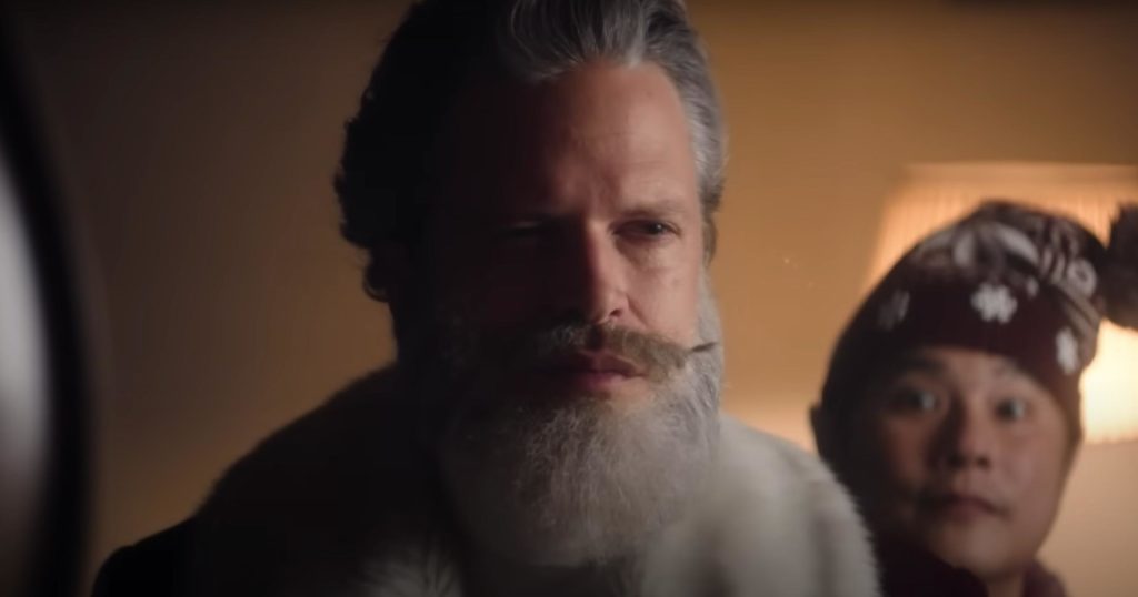 James Kirkland as Santa Claus in Rakuten's Christmas 2022 TV commercial, with an elf behind him