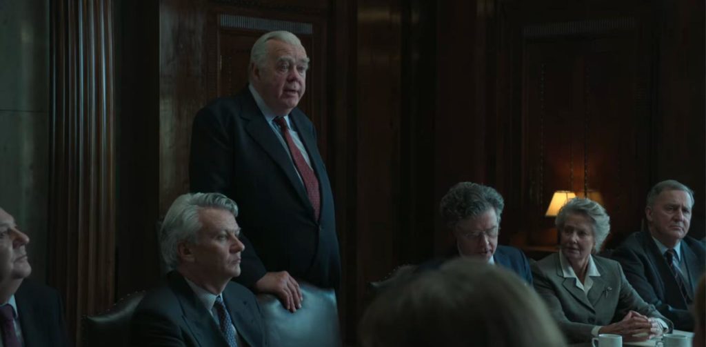 Los actores que representan a la junta directiva de la BBC se sientan alrededor de una mesa de reuniones en la temporada 5 de The Crown
