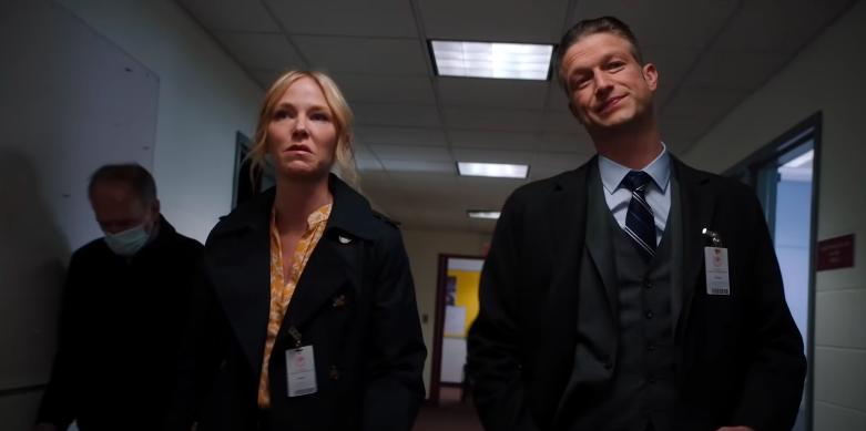 Kelli Giddish como Rollins y Peter Scanavino como Carisi caminan por el pasillo de una estación de policía en Law & Order: SVU