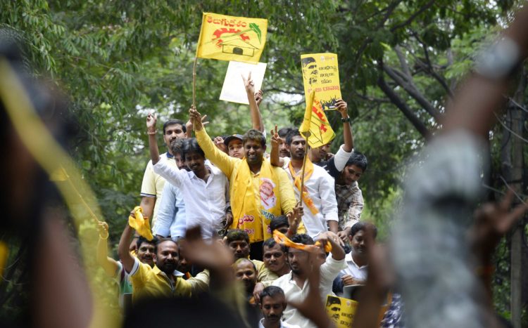 Telugu Desam Party (DTP) supporters celebrate party victory in Seemandhra assembly election by waving banners and holding their hands up high