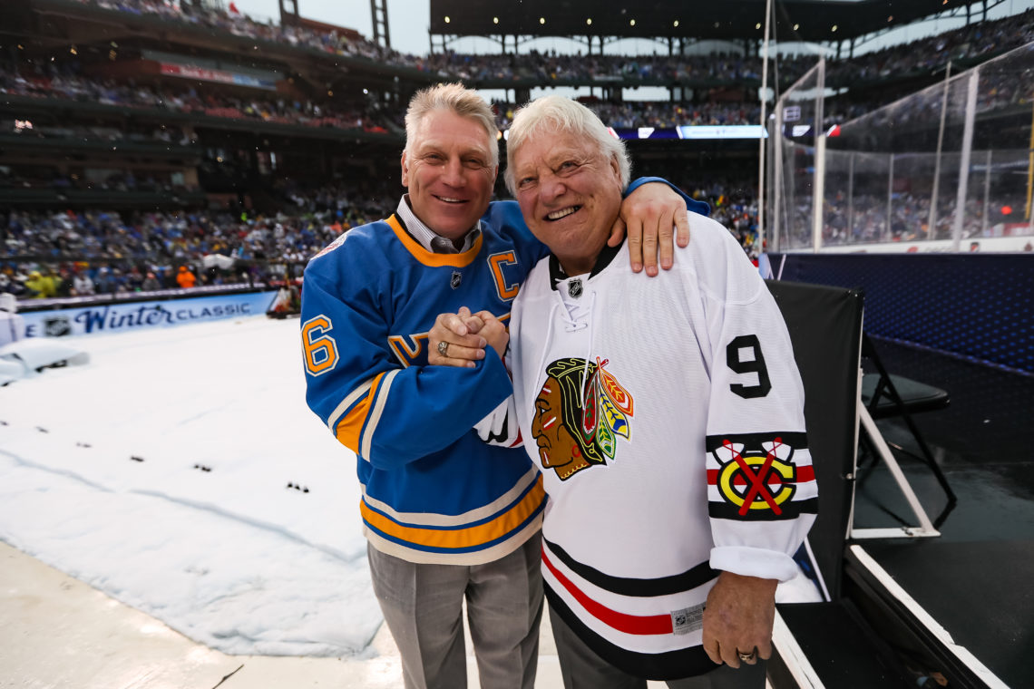 Father and son, Bobby and Brett Hull, clasping hands on the rink