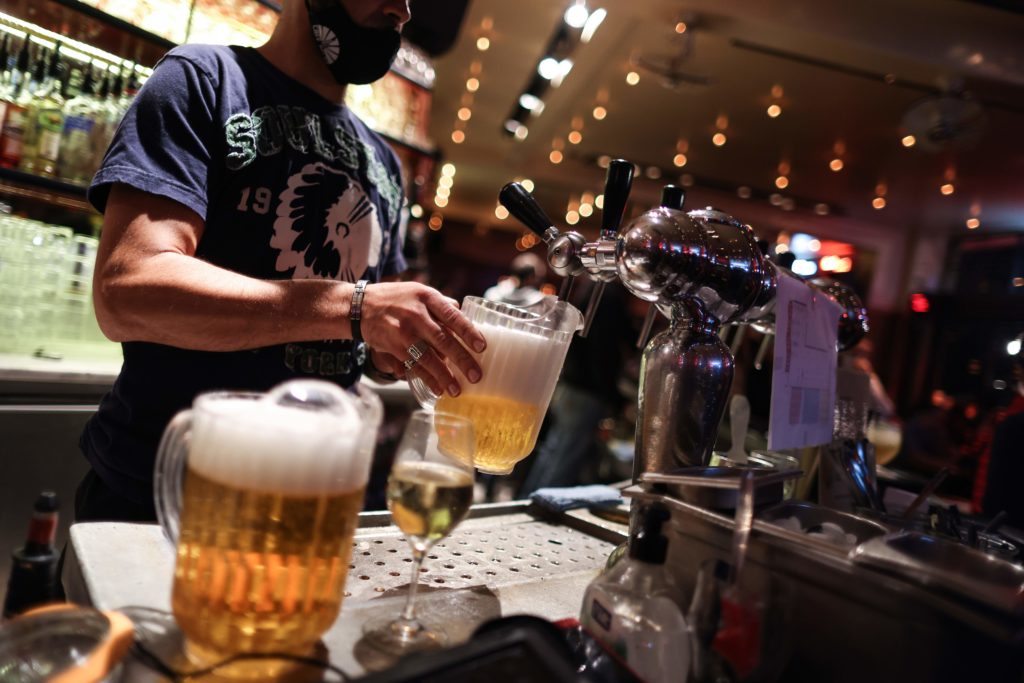 A waiter serves beers at a bar on the eve of the mandatory closure of bars in Brussels, on October 7, 2020, to stop the spread of Covid-19. - In Br...