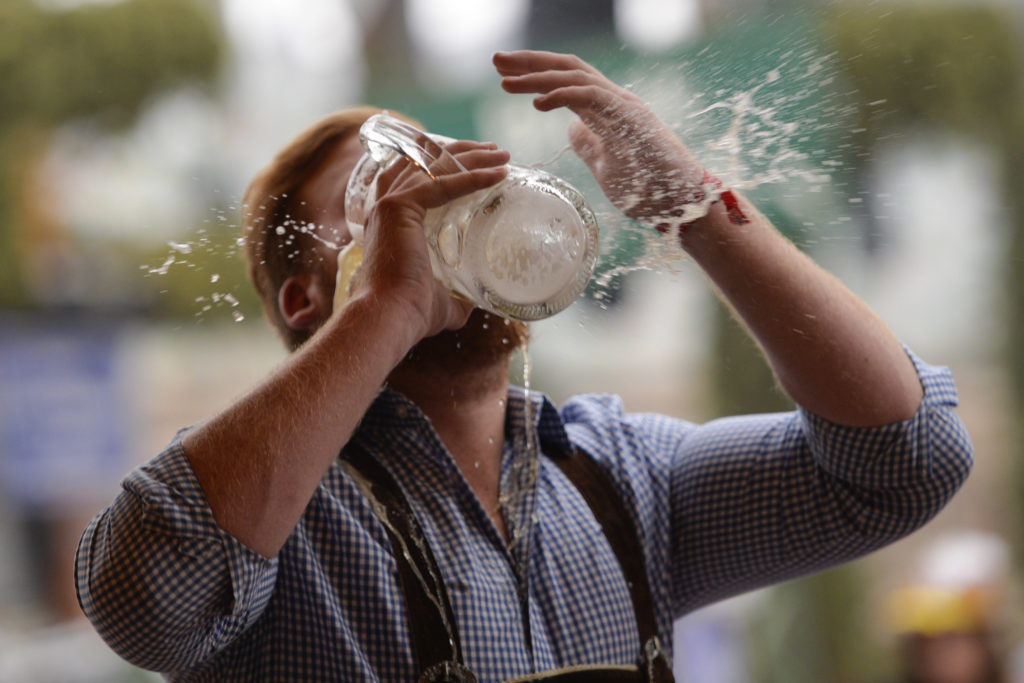 A reveller spills beer as he tries to empty his stein in one sitting at the Hofbraeu tent on the opening day of the 2015 Oktoberfest on September 1...